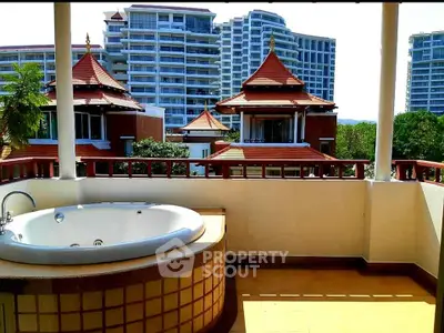 Luxurious balcony with outdoor bathtub and stunning view of modern architecture