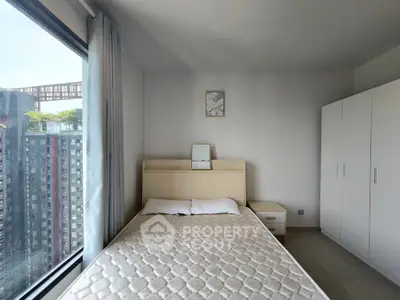 Modern bedroom with large window offering city view, minimalist decor and ample storage space.