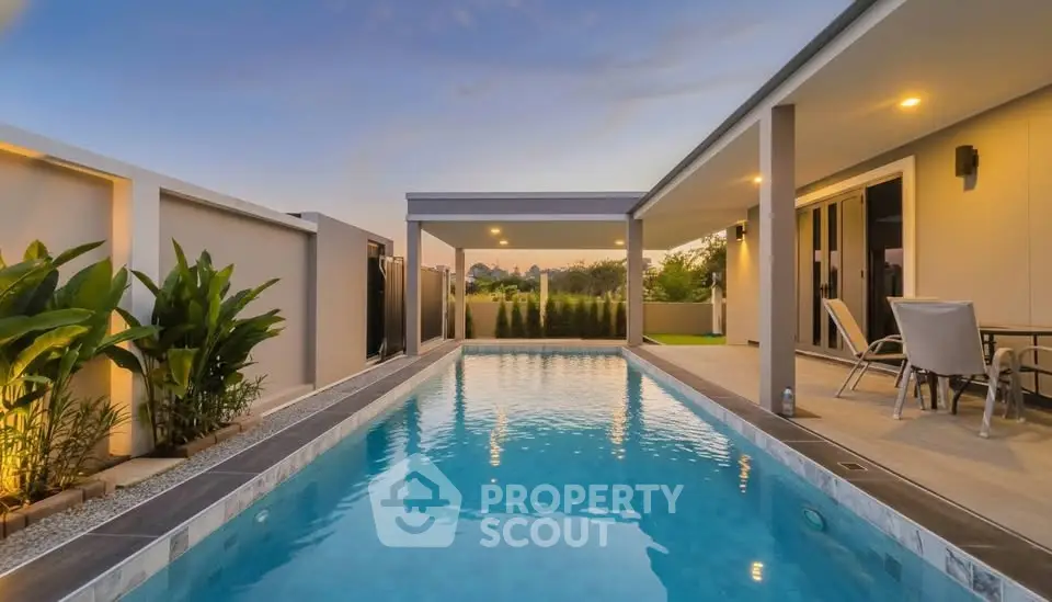 Luxurious modern home with private pool and elegant outdoor seating area at sunset.