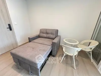 Cozy small living area with a sofa bed and wicker chairs, perfect for compact spaces.