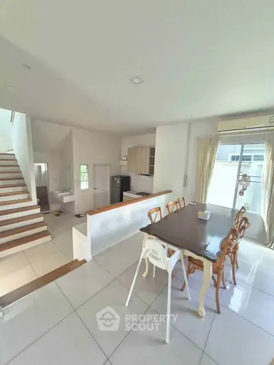 Spacious dining area with elegant wooden chairs and modern kitchen in open layout home.