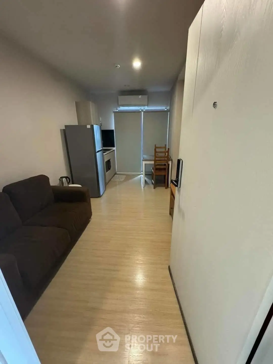 Cozy apartment interior with modern kitchen and living area, featuring sleek appliances and comfortable seating.