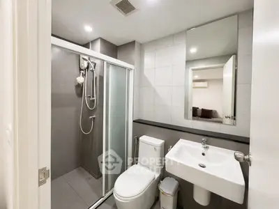 Modern bathroom with sleek shower and contemporary fixtures in stylish apartment.