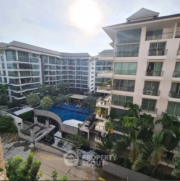 Luxurious residential complex with pool and lush greenery, offering modern living in a serene environment.