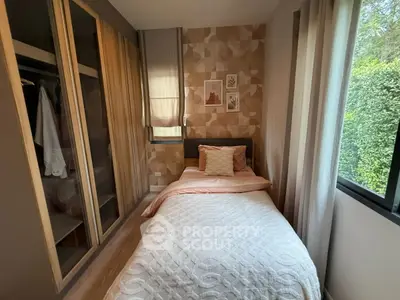 Cozy bedroom with stylish decor and large window overlooking greenery.