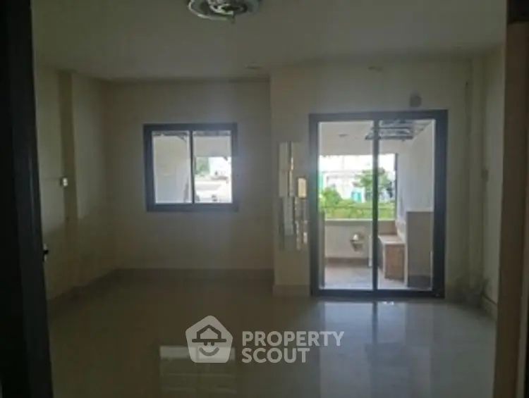 Spacious living room with large windows and balcony access in modern apartment.