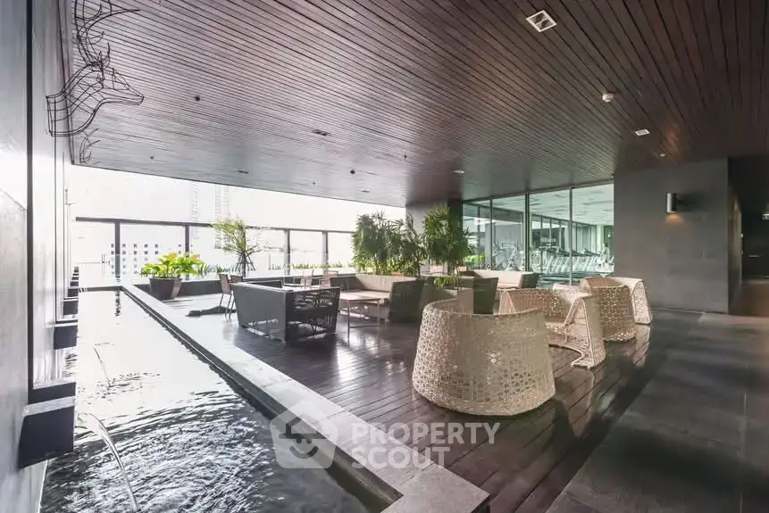 Luxurious modern building with stylish outdoor seating and water feature, perfect for relaxation and social gatherings.