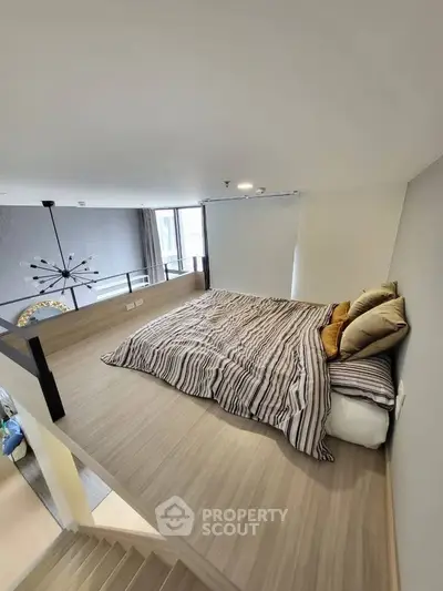 Modern loft bedroom with stylish decor and cozy bedding in a contemporary apartment.