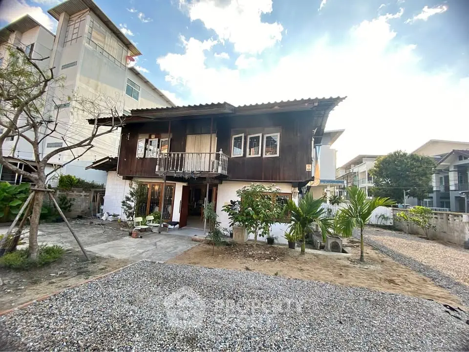 Charming rustic wooden house with spacious garden and gravel driveway, perfect for serene living.