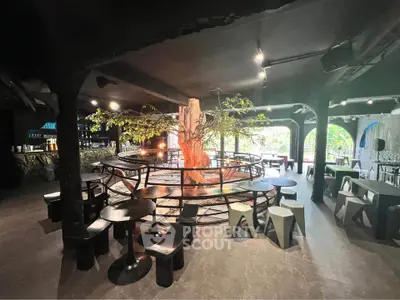 Unique interior space with central tree feature and modern seating, ideal for creative gatherings.