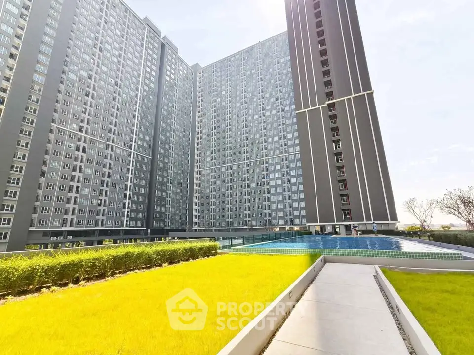 Modern high-rise apartment complex with pool and landscaped garden