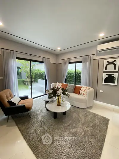 Stylish living room with modern decor and garden view, featuring cozy seating and elegant accents.