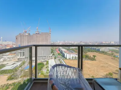 Stunning cityscape view from a high-rise balcony with clear blue skies.