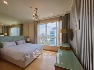 Luxurious bedroom with city view, elegant decor, and ample natural light in a high-rise apartment.