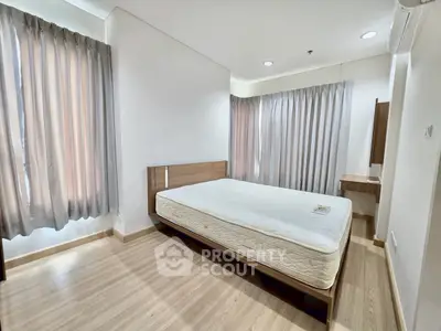 Spacious bedroom with natural light and modern furnishings