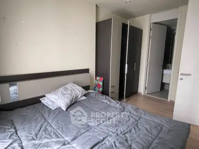 Cozy bedroom with modern furnishings and ensuite bathroom in a stylish apartment.