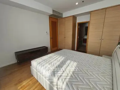 Spacious bedroom with wooden flooring and ample closet space