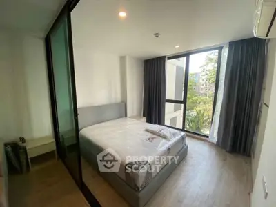 Modern bedroom with large window and minimalist design in a bright apartment.