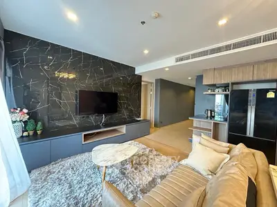 Modern living room with stylish decor and open layout, featuring a sleek TV wall and cozy seating area.