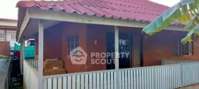Charming rustic brick house with a red roof and inviting porch.