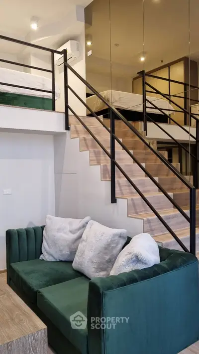 Modern loft apartment with stylish green sofa and cozy mezzanine bedroom.
