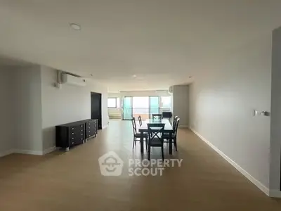 Spacious open-plan living and dining area with modern furnishings and large windows.