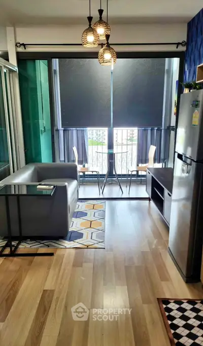 Modern living room with balcony view, stylish decor, and natural light in urban apartment.