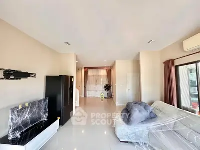 Spacious living room with modern furnishings and large windows for natural light.