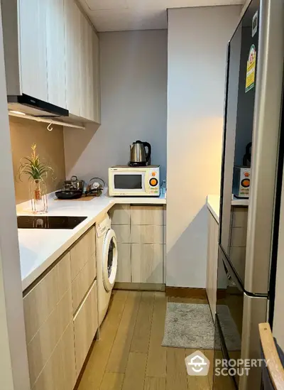 Modern compact kitchen with sleek appliances and wooden cabinetry