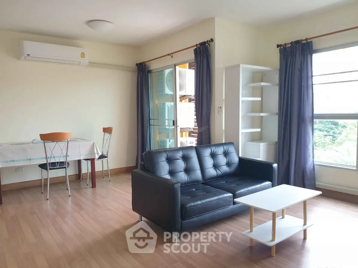 Spacious living room with modern furniture and large windows offering natural light.