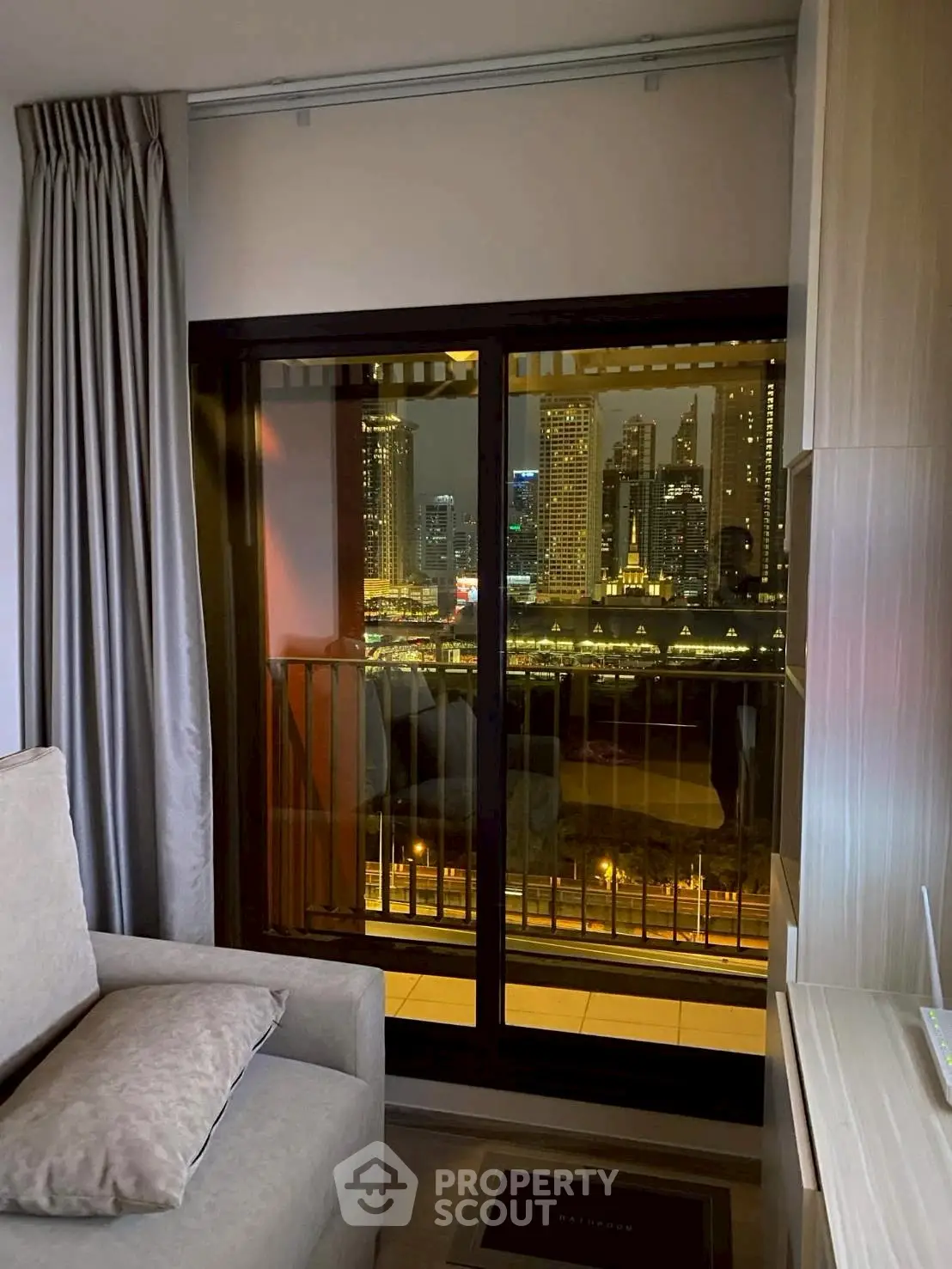 Cozy living room with stunning city view from balcony at night
