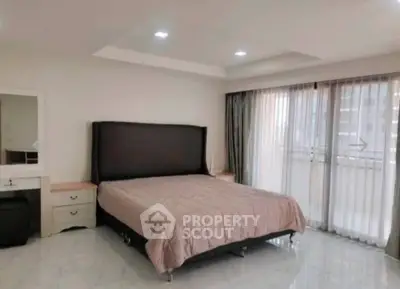 Spacious bedroom with large windows and modern decor in a luxury apartment.