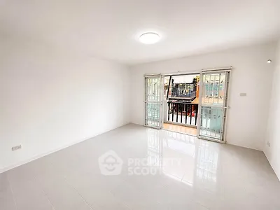 Spacious and bright living room with large windows and balcony access.