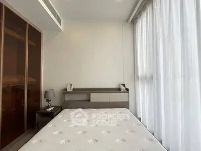 Modern bedroom with sleek design and ample natural light from large windows.