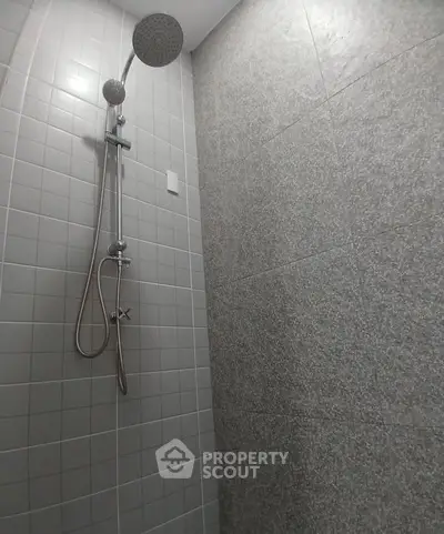 Modern bathroom shower with sleek tile design and rainfall showerhead.