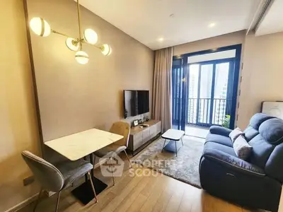Modern living room with cozy seating and balcony view in a stylish apartment.