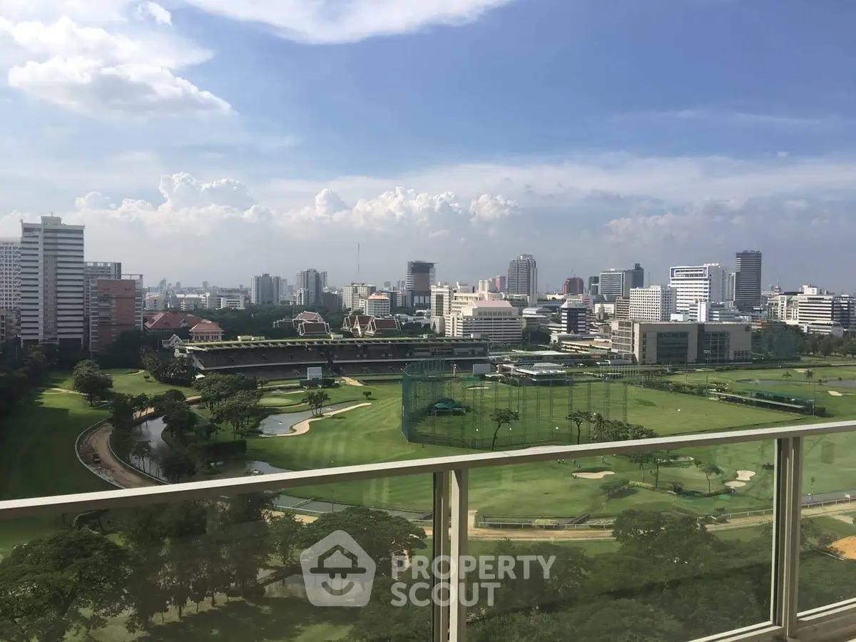 Stunning cityscape view from a high-rise balcony overlooking lush green golf course and skyline.