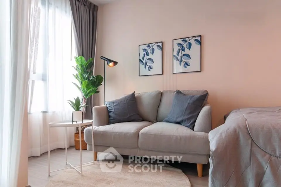 Cozy living room with modern decor, featuring a plush sofa, stylish artwork, and abundant natural light.