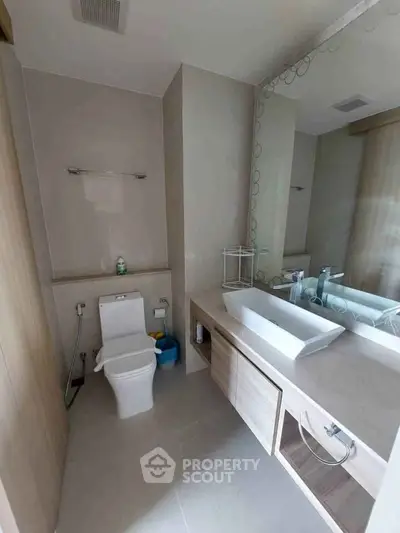 Modern bathroom with sleek vanity and large mirror in a contemporary home.