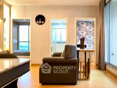 Modern living room with stylish decor and large windows offering natural light and city views.