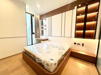 Modern bedroom with stylish wooden accents and large window for natural light.