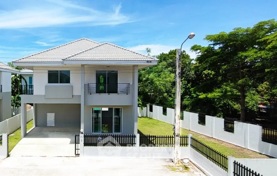 Modern two-story house with spacious driveway and lush greenery