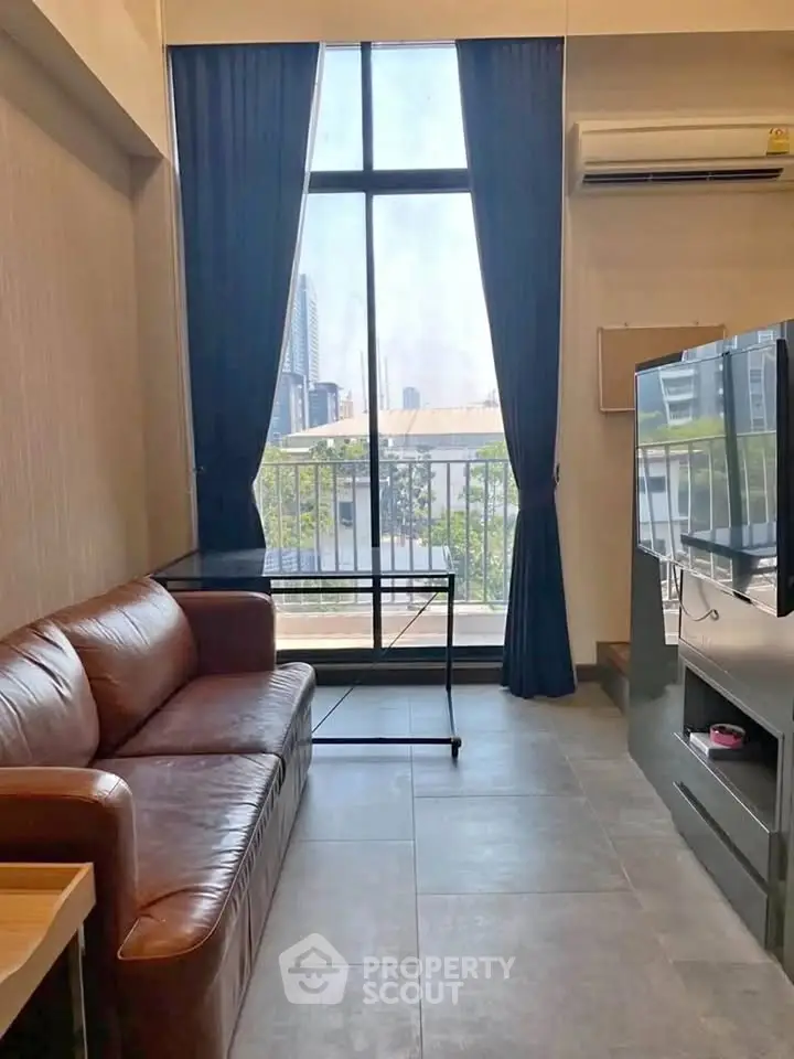 Modern living room with leather sofa and large window offering city view