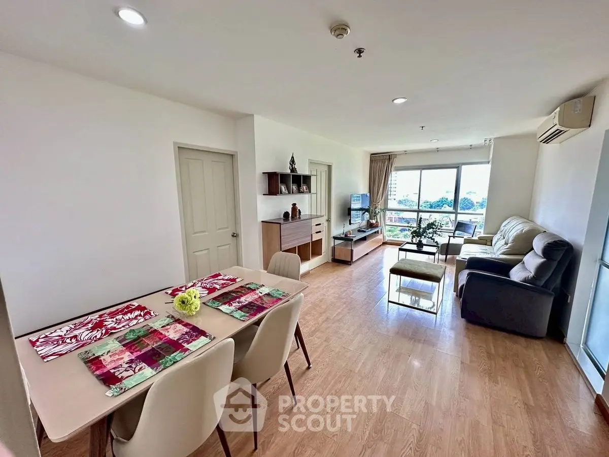 Spacious living room with modern decor and large windows offering a scenic view, perfect for relaxation.