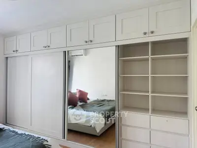 Spacious bedroom with built-in wardrobe and mirrored sliding doors, offering ample storage and modern design.