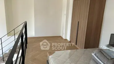 Spacious bedroom with modern wooden flooring and sleek staircase