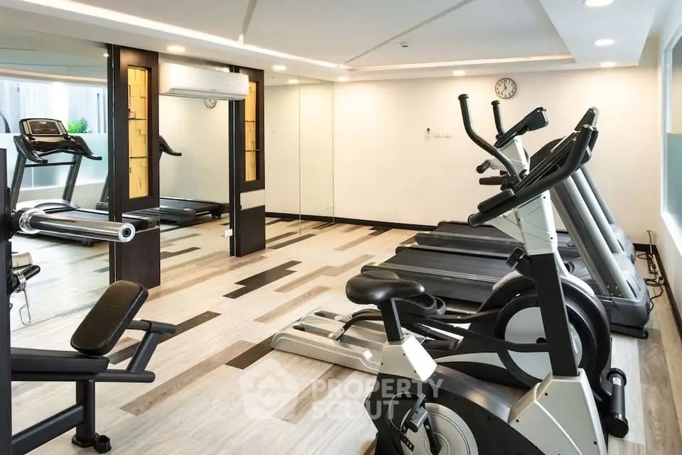 Modern gym with state-of-the-art fitness equipment in luxury residential building.