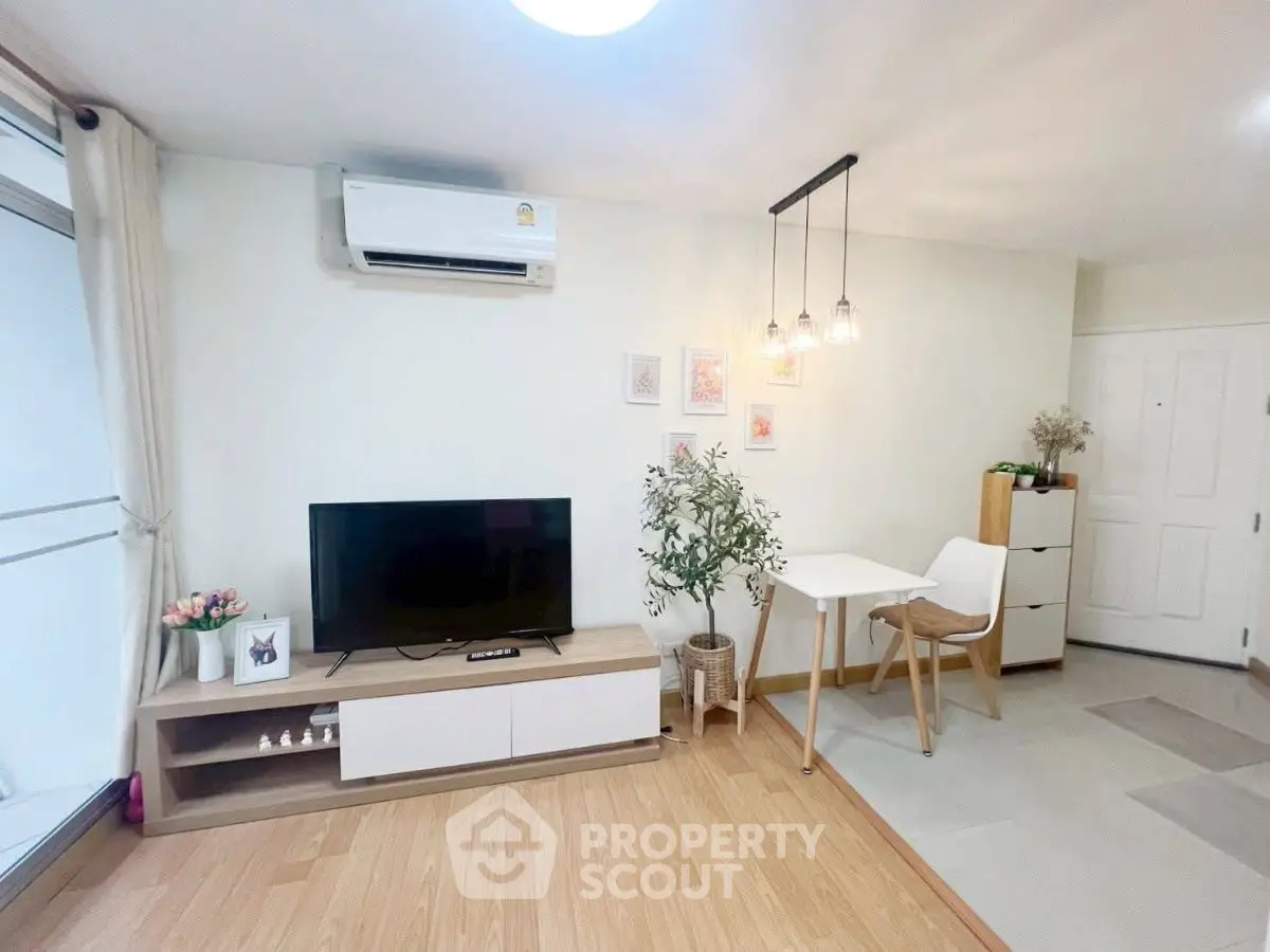 Modern living room with TV, dining area, and stylish decor in a cozy apartment.