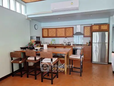 Charming kitchen with wicker chairs and modern appliances in cozy home