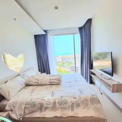 Bright bedroom with large window offering stunning view, modern decor, and wall-mounted TV.